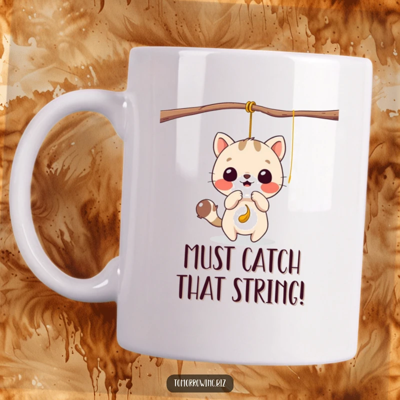 Funny mug showing a cute animal character playfully batting at a dangling, tempting string with focused excitement.